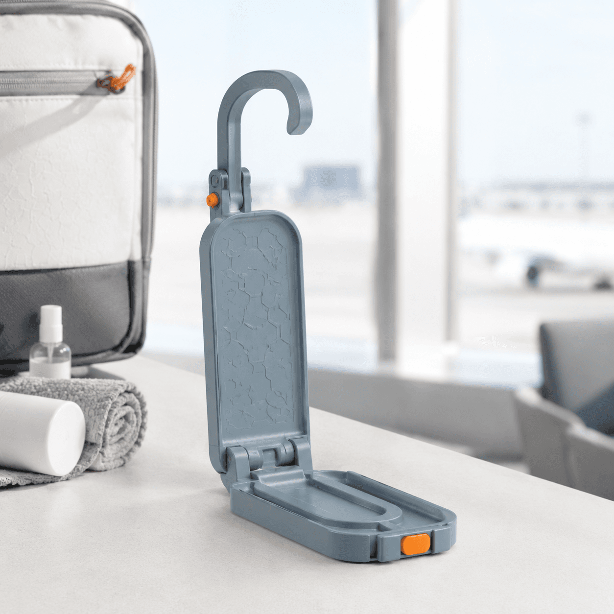 Fog-blue folding toiletry hook shown open on a neutral studio backdrop